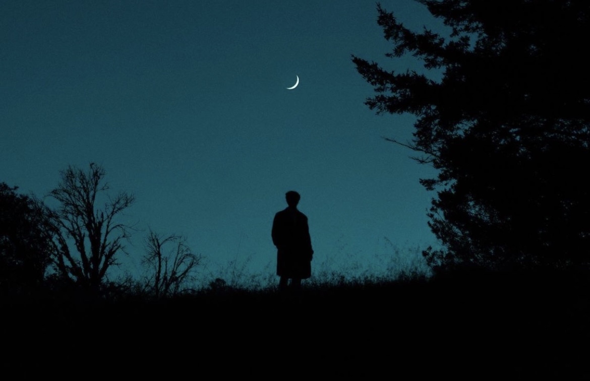 Silhouette under a crescent moon
